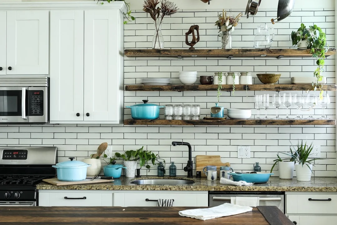 A person wearing protective equipment stands in a modern kitchen during daytime.